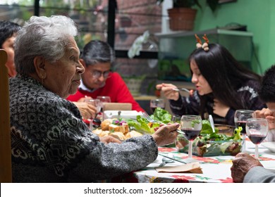 Family Eating And Talking At A Christmas Dinner