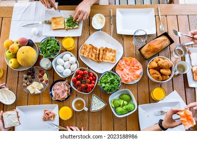 Family Eating Toast With Salmon And Avocado.Cheese, Jamon. Buffet At The Hotel.Nice Table With Lots Of Food.Table Food Top View.Boiled Eggs.Family Eating Breakfast.A Healthy Breakfast For The Family.