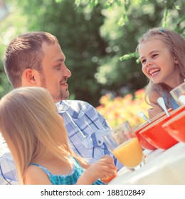 Family Eating Together Outdoors At Park On Backyard. Vintage Style Photo