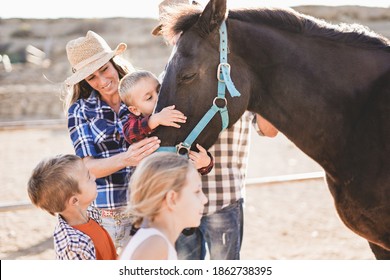 Family enjoy day at horse ranch - Parents and children, family day - Cute little boy kissing a horse - Powered by Shutterstock