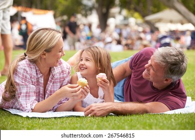 Family Enjoying Cupcakes At Outdoor Summer Event