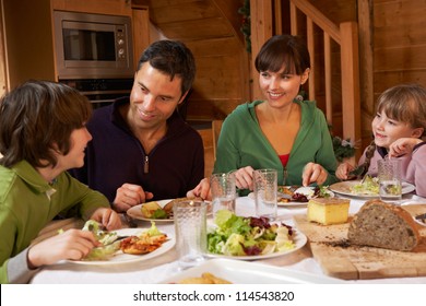 Family Enjoying Meal In Alpine Chalet Together