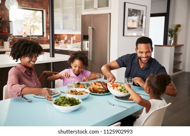 Family Enjoying Meal Around Table At Home Together