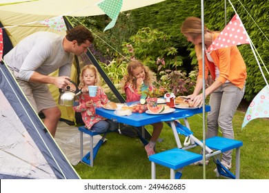 Family Enjoying Meal Outside Tent On Camping Holiday 