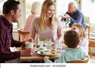 Family Enjoying Meal In Restaurant Together