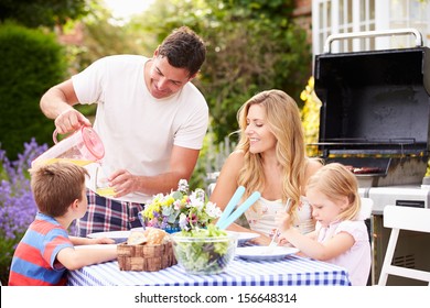 Family Enjoying Outdoor Barbeque In Garden