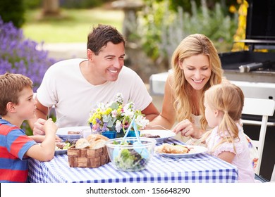 Family Enjoying Outdoor Meal In Garden