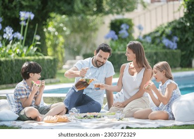 Family enjoying picnic at poolside - Powered by Shutterstock