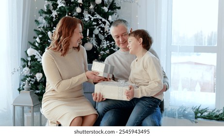 Family enjoying quality time and gift exchange during the festive season in their warm home. A day with family before Christmas. New Year's Eve with family - Powered by Shutterstock