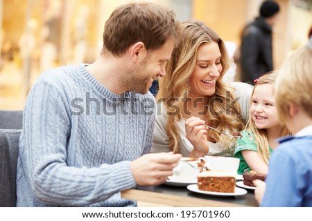 Family Enjoying Snack In Cafe Together