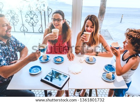 Family Enjoying Snack In Cafe Together.Positive friendly family having breakfast in the coffee shop