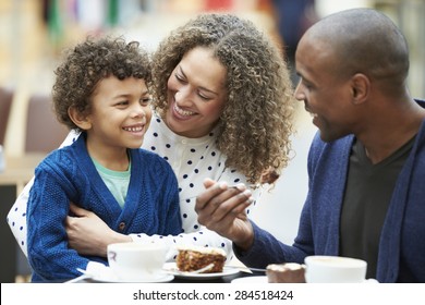 Family Enjoying Snack In Caf\x81_ Together