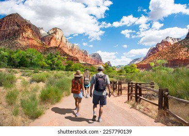 Family enjoying summer mountain trip. People on hiking trip in the red mountains walking on pathway on summer vacation.  Zion National Park, Utah, USA. - Powered by Shutterstock