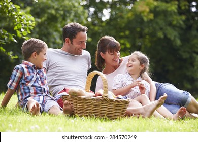 Family Enjoying Summer Picnic In Countryside