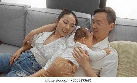 Family enjoying time together in a cozy living room as a mother and father embrace their toddler son in a warm, loving scene of happiness and connection indoors. - Powered by Shutterstock