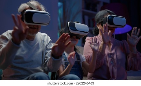 Family enjoying with VR headset, Cheerful girl playing metaverse gaming with wearable VR headset with control handle playing sport gaming online with family at home, Home technology - Powered by Shutterstock