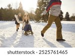 Family enjoying winter nature sledding down snowy slopes on sleds. Happy and laughter with sledding enjoy thrill of sledding together creating cherished memories in frosty outdoors winter nature