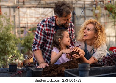 Family enjoys gardening together; mother’s hands cradle the earth while father and daughter plant flowers. - Powered by Shutterstock