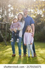 Family Is Everything. Full Length Portrait Of An Affectionate Young Family Of Four Posing In The Garden At Home.