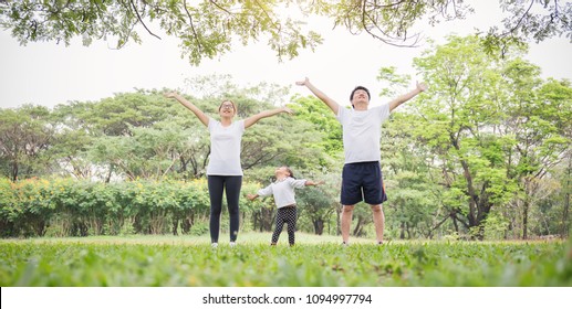 Family exercise jog together breathing fresh air at park. Group of asian family father mother and daughter girl stretching after play sport. Sport health care medical fun freedom concept banner - Powered by Shutterstock