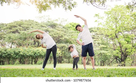 Family exercising and jogging together at the park. Group of asian family father mother and daughter stretching after sport on the grass. Sport health care and medical concept. - Powered by Shutterstock