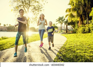 Family Exercising And Jogging Together At The Park