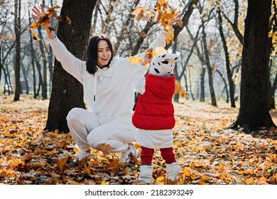 Family Fall Activities. Happy Family Mom And Toddler Baby Girl Playing Outdoors In Fall Park