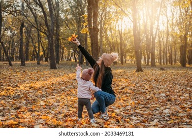 Family Fall Social Distancing Activities. Happy Family Mom And Toddler Baby Girl Playing Outdoors In Fall Park. Little Girl And Her Mother In The Autumn Park. Fall Activities For Toddlers.