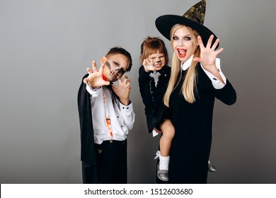 Family In Fancy Dress Showing Scary Gesture Looking At The Camera.- Image