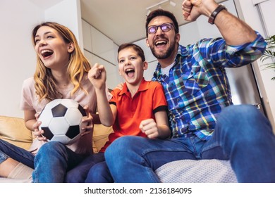 Family of fans watching a football match on TV at home - Powered by Shutterstock