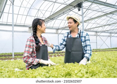 Family Of The Farmer Vegetable In Smart Farm Plant. The Father And The Daughter Discuss To The Organic Vegetables That Are Raised On The Farm.