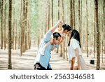 Family father carrying young girl shoulders while walking in forest with mother, Happy Asian family with adorable children in weekend, shoulder carry and happy family kid, dad and mom enjoy together