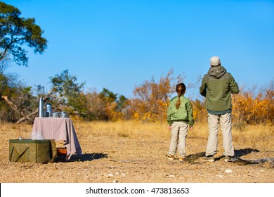 Family Of Father And Child On African Safari Vacation Enjoying Bush Breakfast