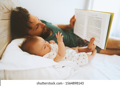 Family Father And Infant Baby Reading Book Fairytale Laying On Bed At Home Lifestyle Dad And Child Daughter Together Parenthood Childhood Concept Fathers Day Holiday