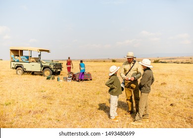 Family Of Father And Kids On African Safari Vacation Enjoying Bush Breakfast