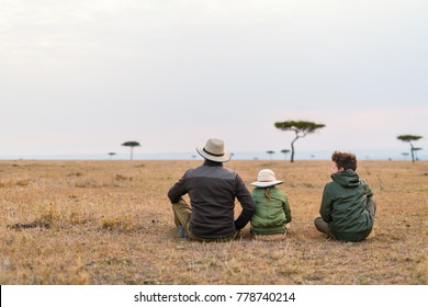 Family Of Father And Kids On African Safari Vacation Enjoying Views Over Masai Mara In Kenya