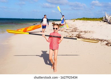 Family Father And Kids Pulling Colorful Kayaks After Paddling At Tropical Ocean Water During Summer Vacation