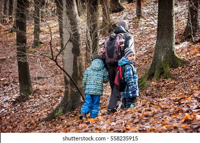 Family, Father With Two Children Hiking In Forest In Winter Or Early Spring. 