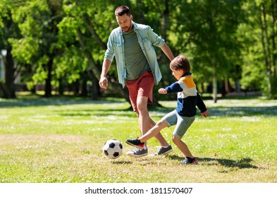 family, fatherhood and people concept - happy father and little son with ball playing soccer at summer park - Powered by Shutterstock