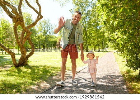 family, fatherhood and people concept - happy smiling father with baby daughter walking at summer park