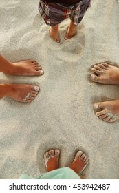 Family Feet On The Sand On The Beach