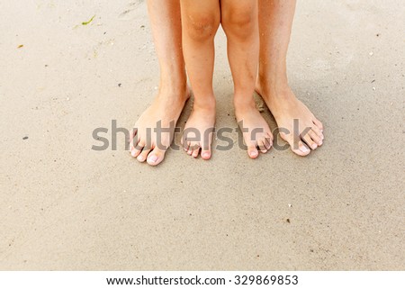 Family feet in the sand on the beach