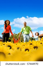 Family In A Field Of Beautiful Yellow Sunflowers With A Blue Sky On The Background