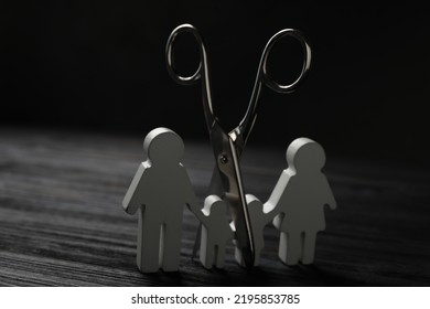 Family Figure And Scissors On Black Wooden Table. Relationship Problems Concept