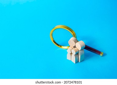 Family figurines and magnifying glass. Finding a partner to create a family. Adoption of children. Demographic research. Genetic tests, health analyzes. Sociology. Social experiment. Life insurance. - Powered by Shutterstock