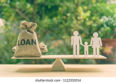 Family finance / financial loan and risk management concept : Loan bags, white acrylic cut (dad, mom, son) on basic balance scale, depicts loan between family members, not use a bank or credit union.