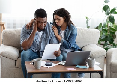 Family Financial Crisis Concept. Depressed Black Couple Looking At Invoice, Not Able To Pay Huge Bills, Suffering From Coronacrisis At Home