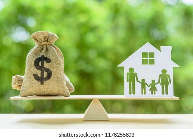 Family financial management, mortgage and payday loan or cash advance concept : Dollar bags, 4 members family under a house or shelter on a balance scale, depicts short term borrowing for a residence. - Shutterstock ID 1178255803