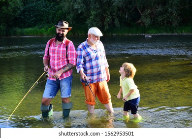 Family Fishermen Fishing With Spinning Reel. Dad And Son Fishing At Lake. 3 Men Fishing On River In Summer Time. Happy Grandfather And Grandson Are Fishing On The River