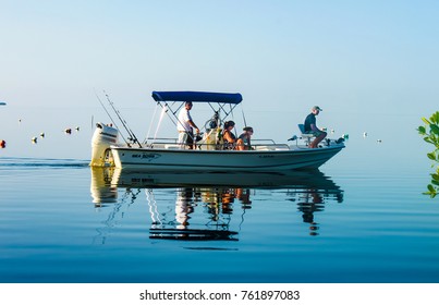 Family in fishing boat on very calm water where the ocean blends into the sky off Cudjoe Key Florida USA circa August 2010
